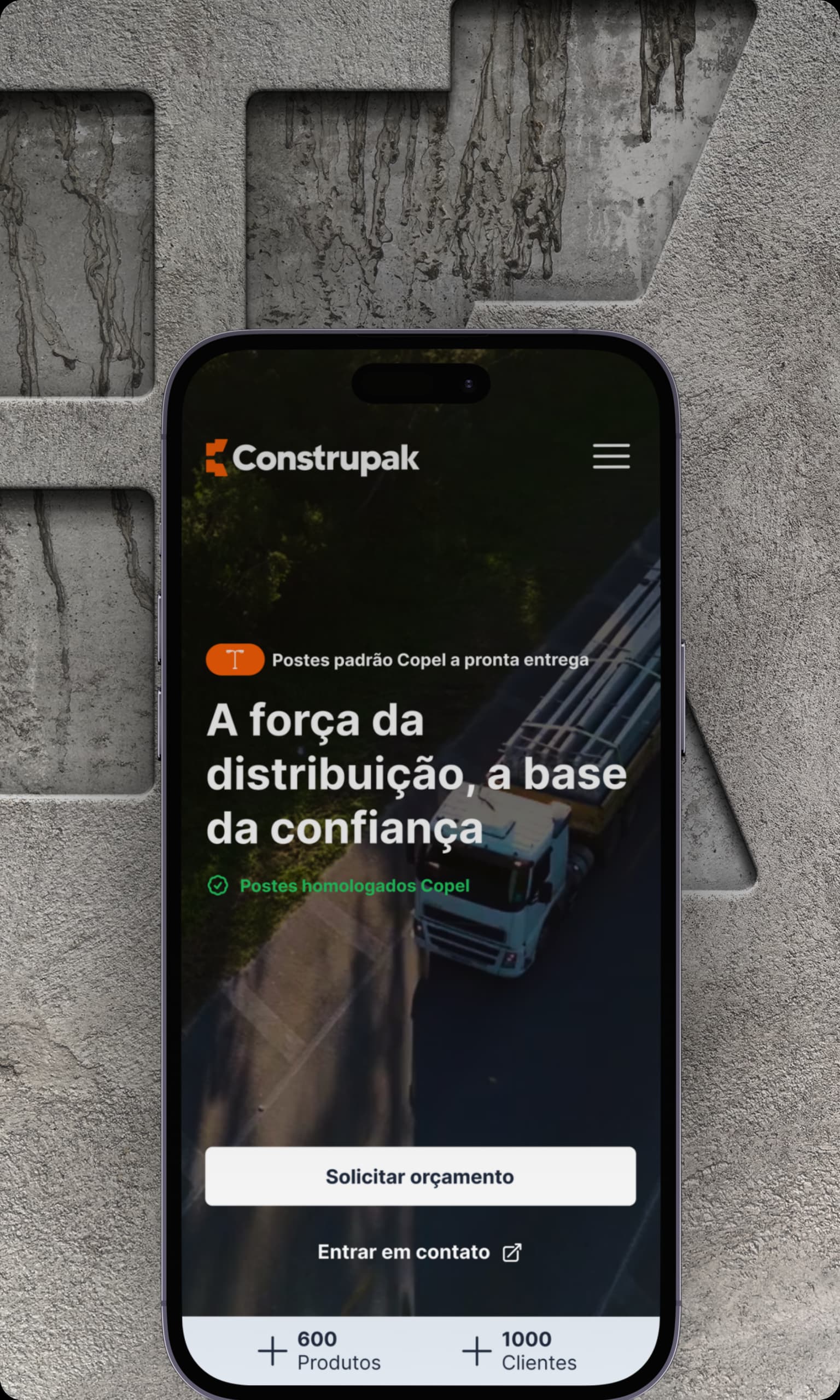 Screenshot de um aplicativo móvel da Construpak. A tela mostra um fundo escuro com a imagem de um caminhão e texto em português. O título principal diz 'A força da distribuição, a base da confiança'. No topo há uma etiqueta laranja indicando 'Postes padrão Copel a pronta entrega' e abaixo um texto verde 'Postes homologados Copel'. A tela possui dois botões: 'Solicitar orçamento' e 'Entrar em contato'. Na parte inferior, há dois contadores: '600 Produtos' e '1000 Clientes'. O logotipo da Construpak aparece no topo da tela junto com um menu hamburguer.